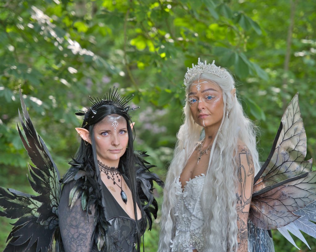 Detailreiches Fantasy-Porträt von zwei Feen im Wald – helle und dunkle Elfenfigur mit Flügeln, professionelle Fantasy Fotografie. Ein Bild von Thorsten Schwarz.