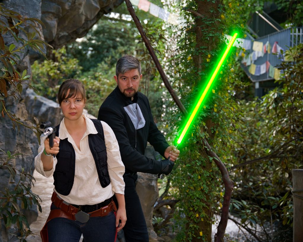 Star Wars Cosplayfoto mit zwei Charakteren – eine Figur mit Blaster, die andere mit grünem Lichtschwert, professionelle Cosplay Fotografe.