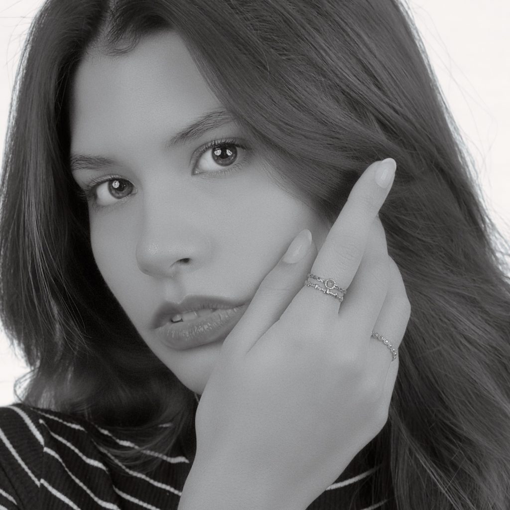Schwarz-Weiß-Portrait einer Frau mit ausdrucksvollem Blick und Schmuck – künstlerische Portraitfotografie im Studio.