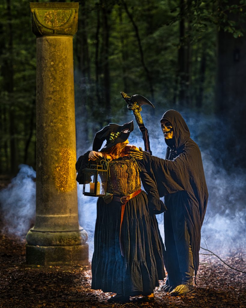 Fantasy-Szene im Wald mit einer Hexe, die eine Laterne trägt, während eine todähnliche Gestalt mit Sense hinter ihr steht